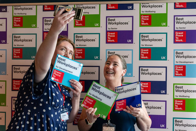 Photo of two women at a For All Event taking a selfie with their best Workplaces plaques